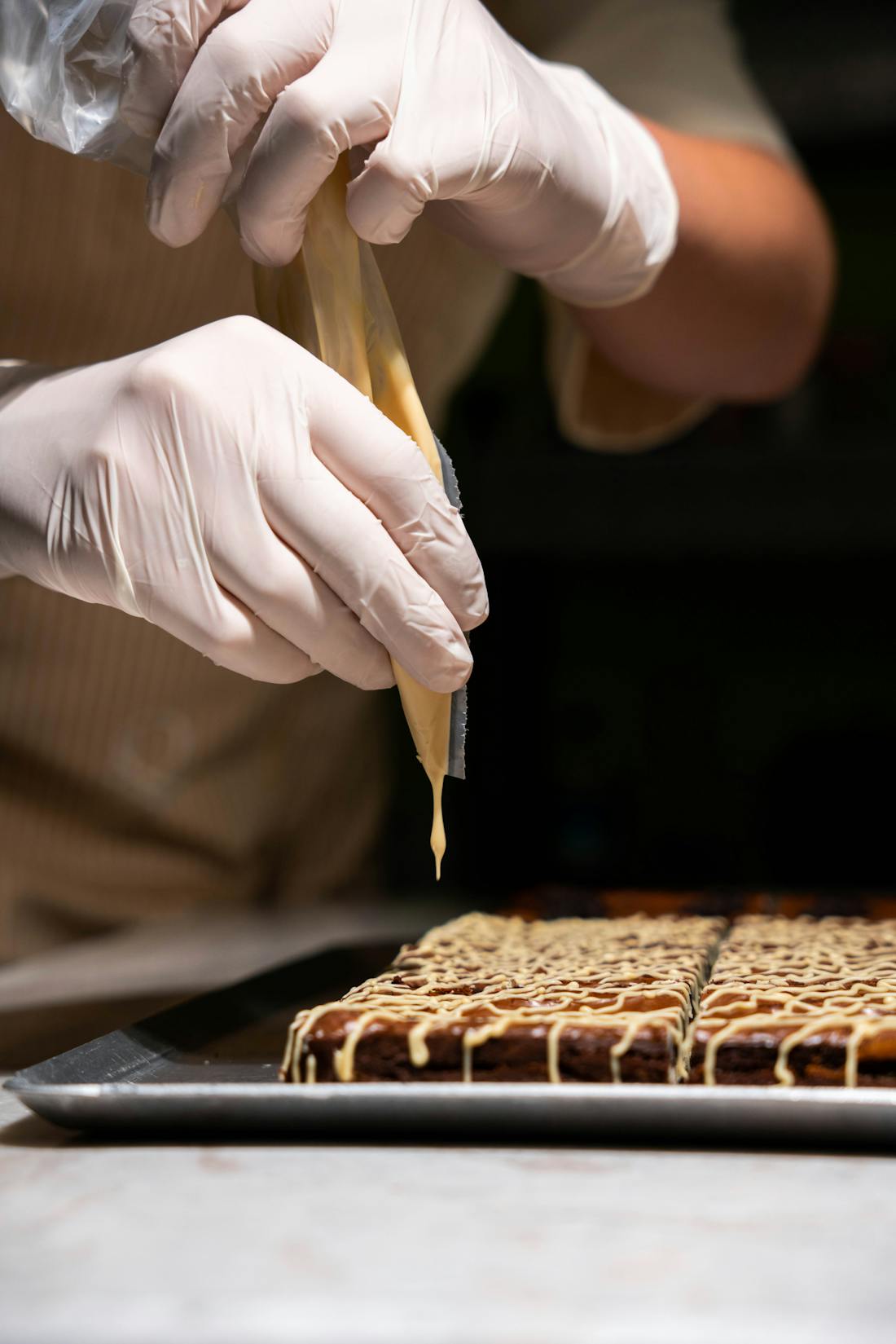 ケーキにクリームを絞るパティシエの手元